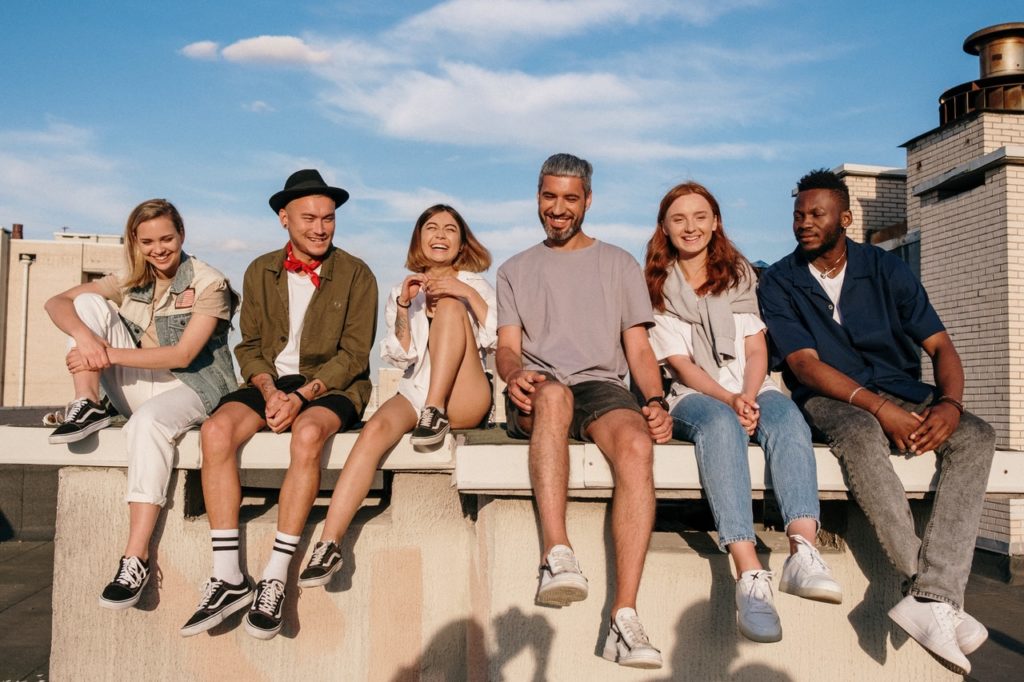 A group of people sitting on concrete on a building rooftop.