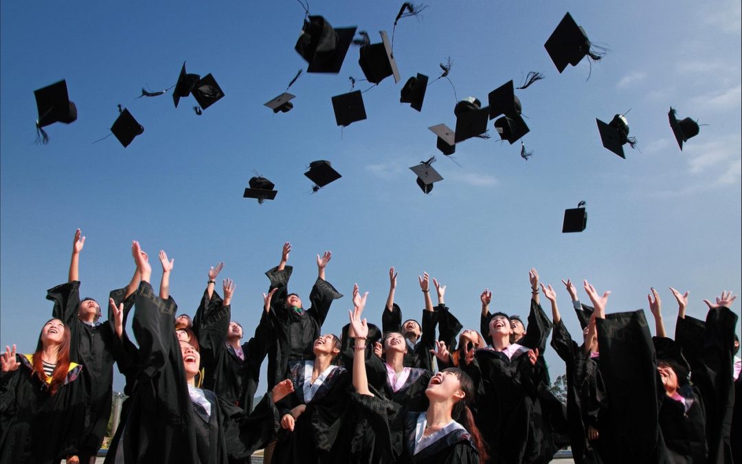 newly-graduated-people-wearing-black-academy-gowns-throwing-hats-up-in-the-air